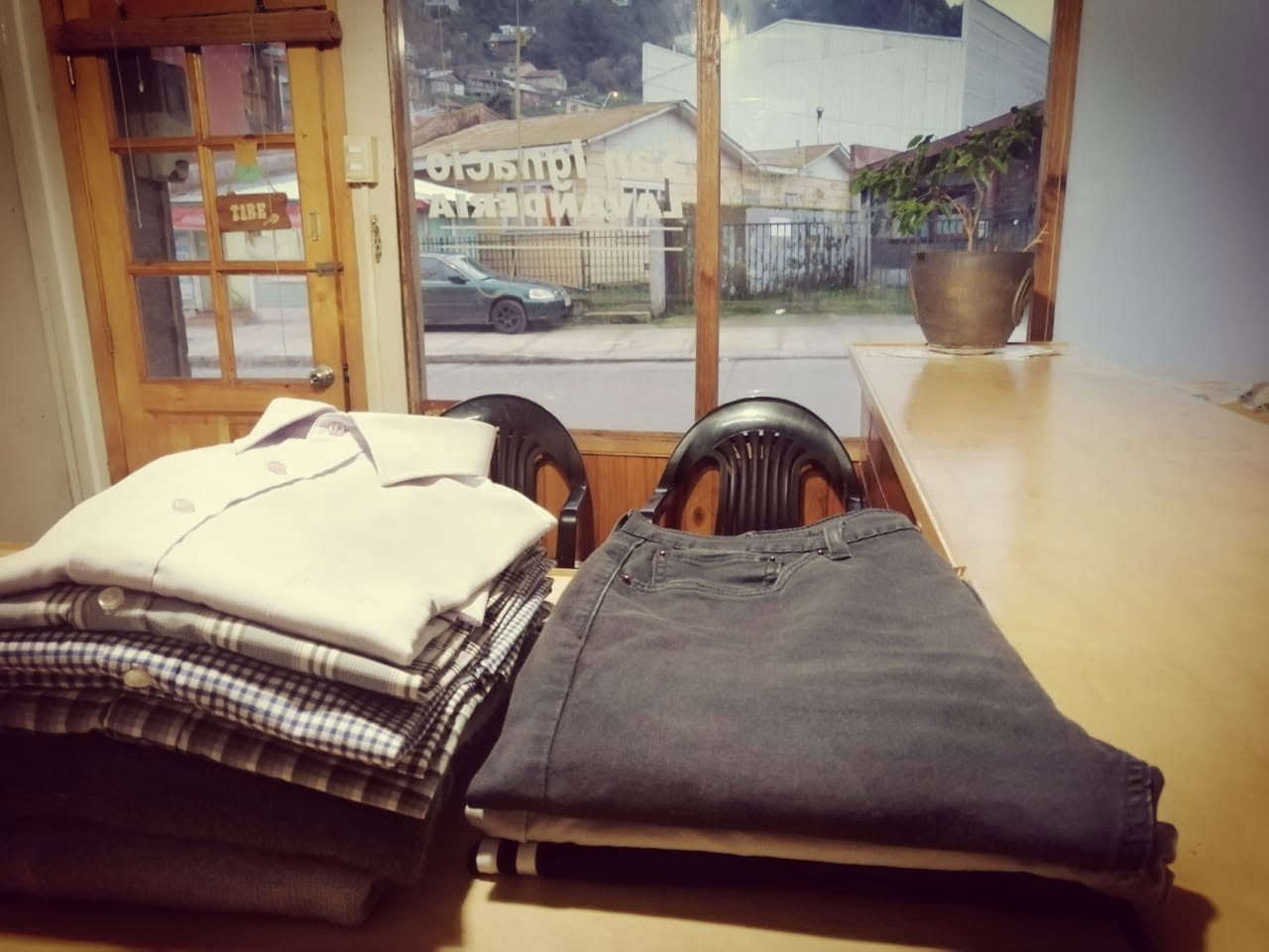 Ropa doblada sobre el mesón junto a la ventana